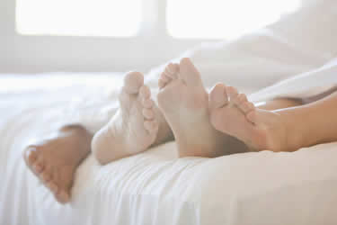 couples feet in bed