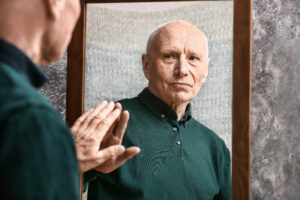 Senior man looking in mirror